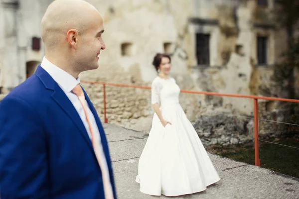 Happy newlyweds on a walk by old castle — Stock Photo, Image