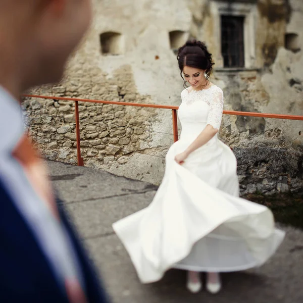 Glückliches Brautpaar beim Spaziergang am alten Schloss — Stockfoto