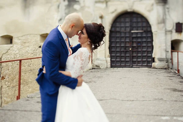 Heureux jeunes mariés sur une promenade par le vieux château — Photo