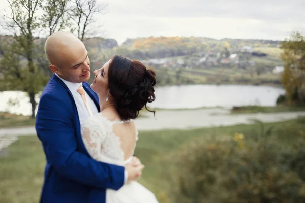 Feliz recém-casados por lago de outono — Fotografia de Stock