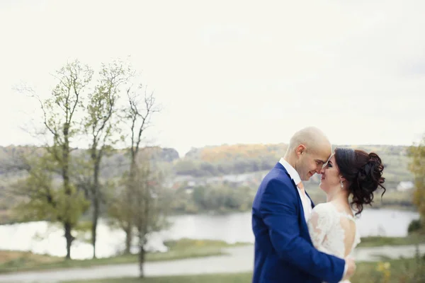 Feliz recém-casados por lago de outono — Fotografia de Stock