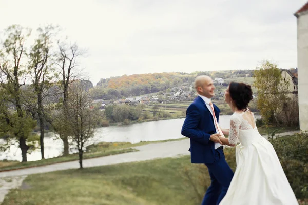 Feliz recém-casados por lago de outono — Fotografia de Stock