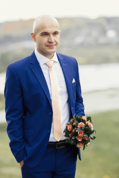 Bonito noivo com buquê de casamento — Fotografia de Stock