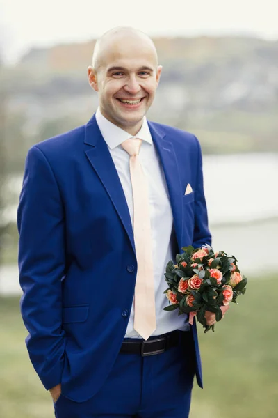 Handsome groom with wedding bouquet — Stock Photo, Image