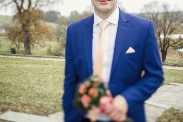Schöner Bräutigam mit Brautstrauß — Stockfoto