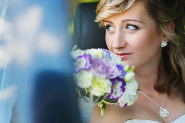Невеста держит букет в машине — стоковое фото