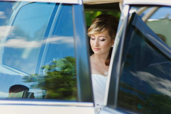 Bride holds bouquet  in the car — Stock Photo, Image