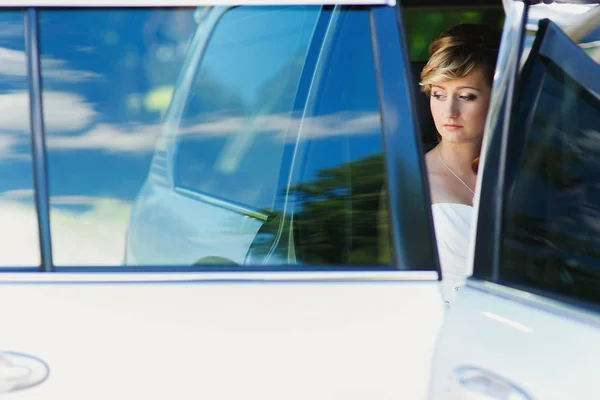 Bride holds bouquet  in the car — Stock Photo, Image