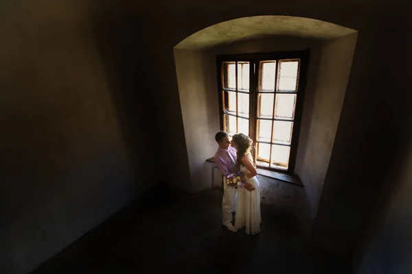 Kussen bruidspaar door raam — Stockfoto