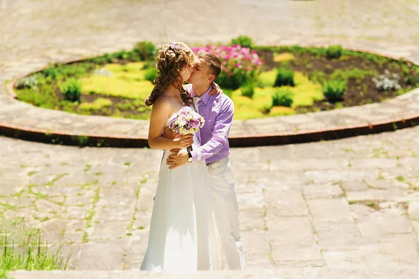 Casamento casal anda em torno de canteiro de flores — Fotografia de Stock