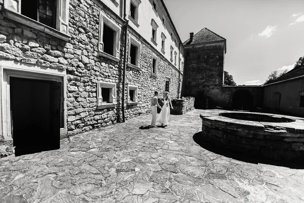 Wedding couple walking by old castle