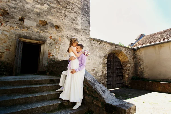 Wedding couple walking by old castle — Stock Photo, Image