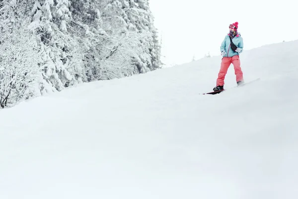 Snowboardåkare kvinna i snötäckta berg — Stockfoto