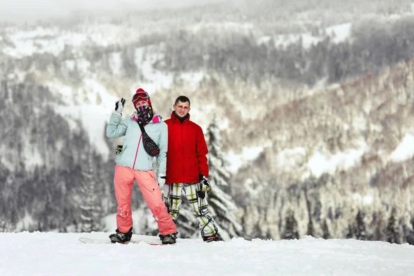 Paar auf den Snowboards in den Bergen — Stockfoto