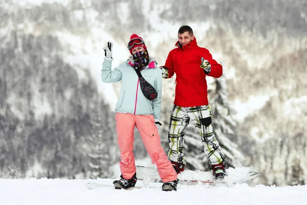Par på snowboards i bergen — Stockfoto