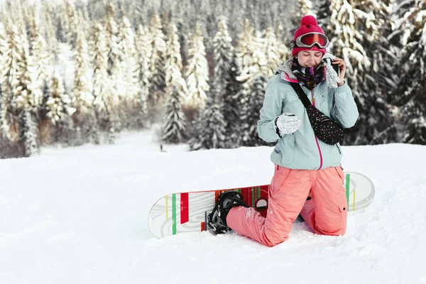 Snowboarder woman in snowy mountains