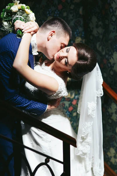 Recém-casados se beijando nas escadas — Fotografia de Stock