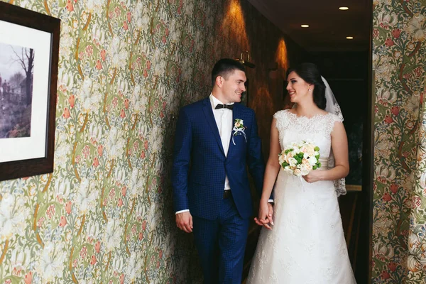 Les jeunes mariés marchent le long du couloir — Photo