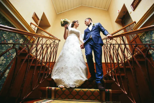 Recém-casados em pé nas escadas — Fotografia de Stock