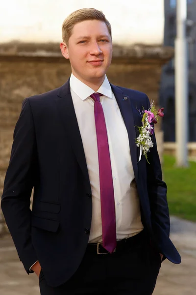 Brudgummen i kostym med violett slips och boutonniere — Stockfoto