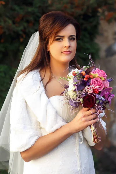 Pretty bride with violet bouquet