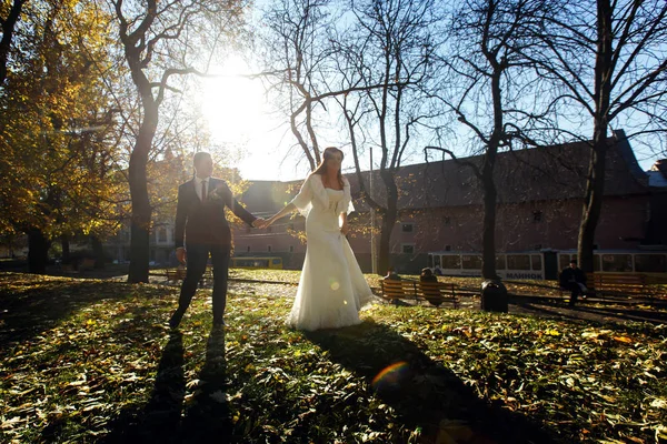 Jonggehuwden op een wandeling in de herfst park — Stockfoto