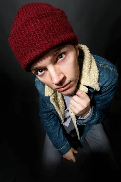 Man in jeans jacket and red hat