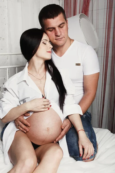 Чоловік і вагітна жінка ніжно обіймаються — стокове фото