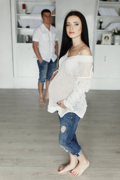 Любляча вагітна пара в світлій кімнаті — стокове фото