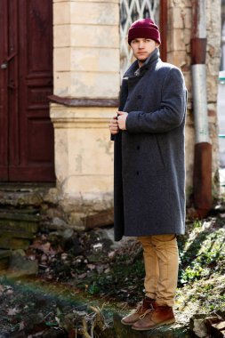 Kalıntılar üzerinde kırmızı şapkalı genç adam 