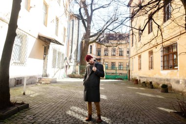 Çocuk sokakta gri paltolu 