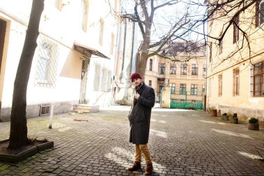 Çocuk sokakta gri paltolu 