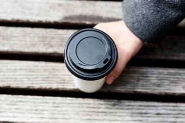 Elinde kahve tutan adam.