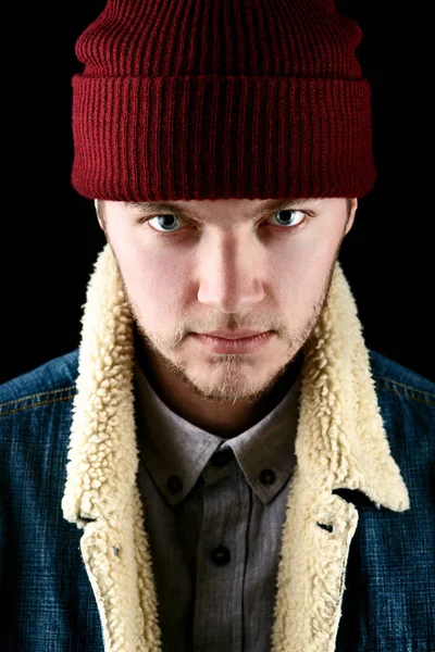 Man in jeans jacket and red hat