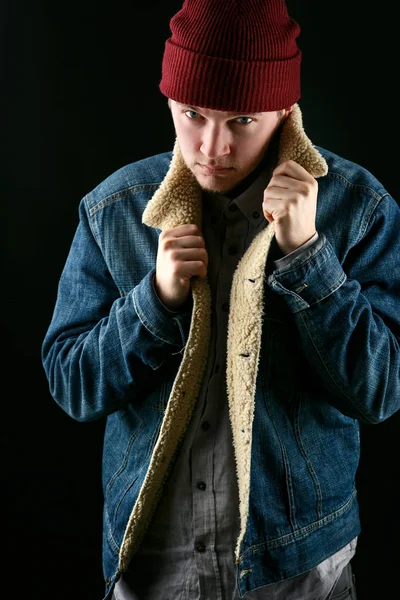 Man in jeans jacket and red hat