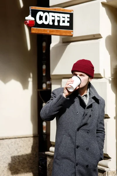 Hombre de sombrero rojo con café en la calle — Foto de Stock