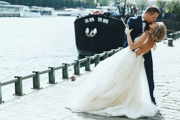 优雅的新郎和新娘在豪华礼服摆在塞纳河前的巴黎某处 — 图库照片