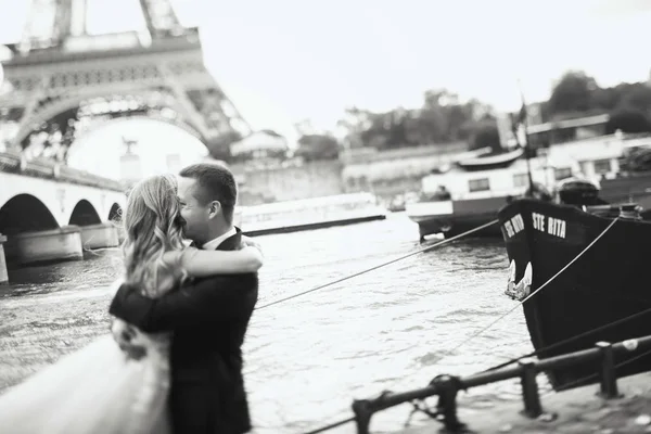 豪华婚礼情侣摆在塞纳河和埃菲尔铁塔前的巴黎某处 — 图库照片