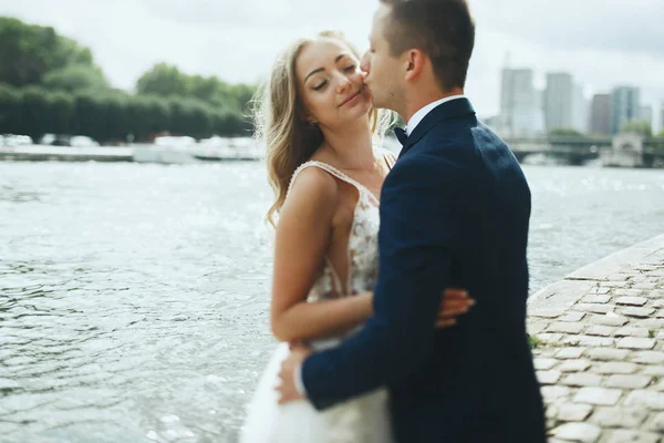 Luxury wedding couple poses before river Seine  somewhere in Paris