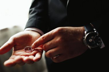 Adam onun elleri altın alyans tutar