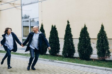 Mutlu bir adam ve kadın modern bir bina boyunca çalıştırın