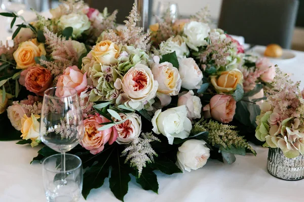 Sofra zengin pembe ve beyaz güller ve peonies eğreltiotu yaprakları ile süslenmiş