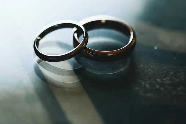 夕食のテーブル上の光のスポットにある黄金の結婚指輪 — ストック写真