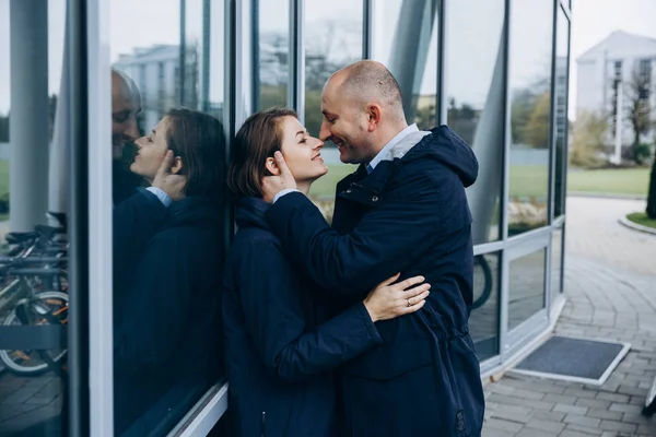 男人和女人亲吻对方招标站在现代玻璃建筑之前 — 图库照片