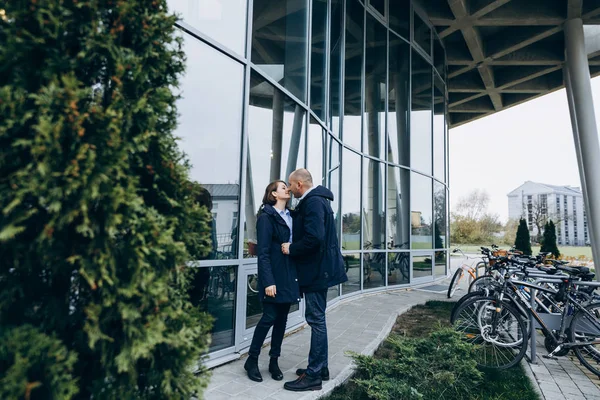 男人和女人亲吻对方招标站在现代玻璃建筑之前 — 图库照片