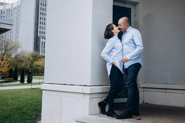 亲吻情侣在灰色建筑前的脚步上摆姿势 — 图库照片