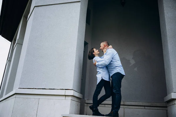 亲吻情侣在灰色建筑前的脚步上摆姿势 — 图库照片
