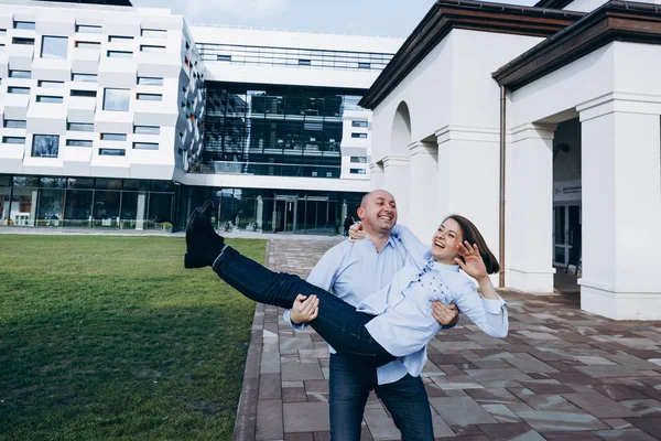 Homem Segura Senhora Alegre Seus Braços Diante Edifício Moderno — Fotografia de Stock