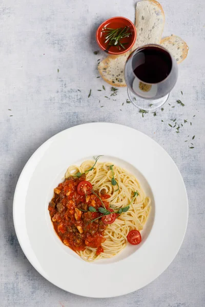 Beyaz tabakta kiraz domatesli bolonez makarnası.