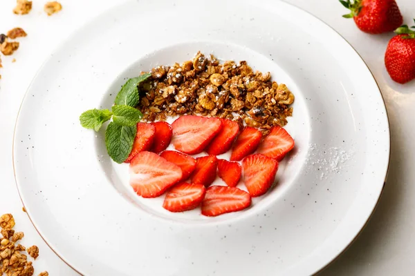 白盘上有草莓和薄荷糖的格拉诺拉 — 图库照片